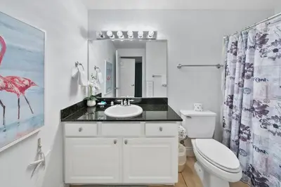 a white bathroom with a sink and a toilet at Calypso 1007E in Panama City Beach