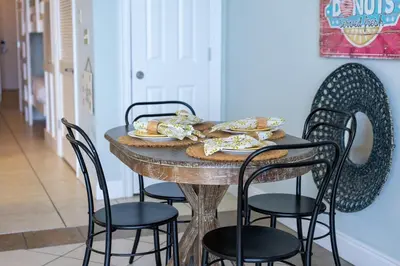 a table with chairs and plates of food on it at Calypso 1007E in Panama City Beach