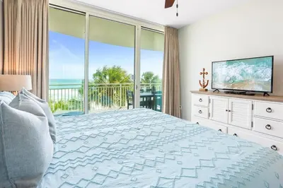 a bedroom with a large bed and a large window at Aqua 203 in Panama City Beach