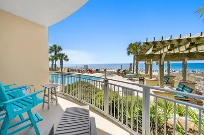 a balcony with chairs and a view of the beach at Aqua 203 in Panama City Beach