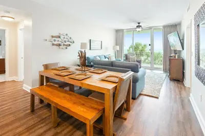 a living room with a table and a couch at Aqua 203 in Panama City Beach