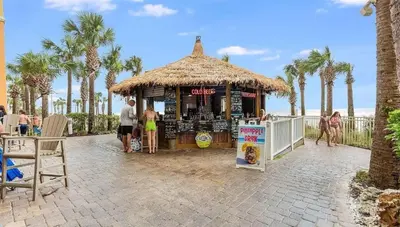 a kiosk on the beach with palm trees at Calypso 1607E in Panama City Beach