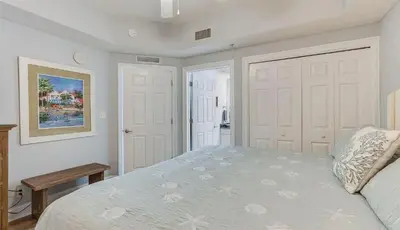 a bedroom with a bed and two white doors at Calypso 1607E in Panama City Beach