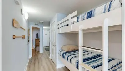 a bedroom with two bunk beds and a hallway at Calypso 1607E in Panama City Beach