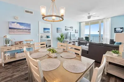 a dining room and living room with a table and chairs at Aqua 408 in Panama City Beach