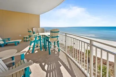 a balcony with chairs and a table and the ocean at Aqua 408 in Panama City Beach