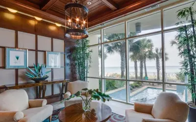 a living room with a large window and a pool at Aqua 410 in Panama City Beach