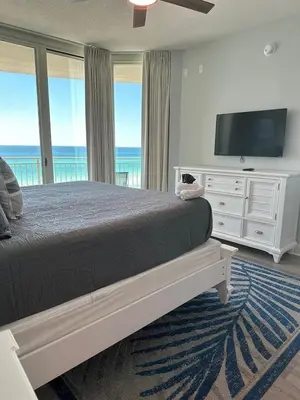 a bedroom with a large bed and a television at Aqua 410 in Panama City Beach