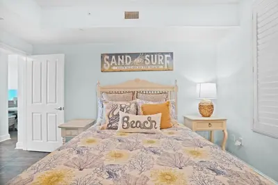 a bedroom with a bed with a sign on it at Aqua 603 in Panama City Beach