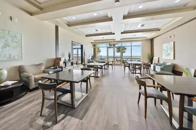 a waiting room at a hotel with tables and chairs at Aqua 603 in Panama City Beach