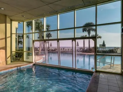 a large swimming pool in a building with windows at 609 Aqua in Panama City Beach