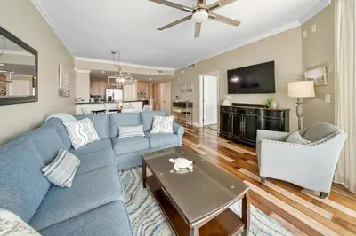 a living room with a blue couch and a table at 609 Aqua in Panama City Beach