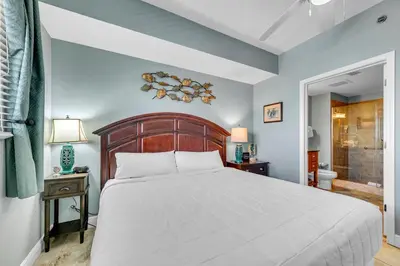 a bedroom with a large bed and a bathroom at Sterling Breeze 1903 in Panama City Beach
