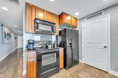a kitchen with a stove and a refrigerator at Sterling Breeze 1903 in Panama City Beach