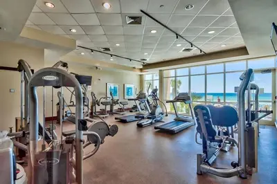 a gym with treadmills and exercise equipment in a building at Aqua 705 in Panama City Beach