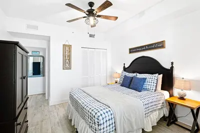 a bedroom with a bed and a ceiling fan at Aqua 705 in Panama City Beach