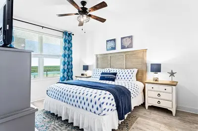 a bedroom with a bed and a ceiling fan at Aqua 705 in Panama City Beach