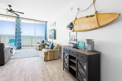 a living room with a surfboard hanging on the wall at Aqua 705 in Panama City Beach