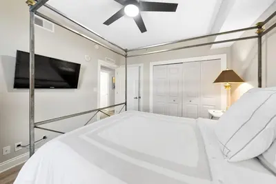 a white bedroom with a bed and a ceiling fan at Calypso 908W Stunning condo, beach front, and immaculate in Panama City Beach
