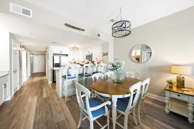 a kitchen and dining room with a table and chairs at Calypso 908W Stunning condo, beach front, and immaculate in Panama City Beach