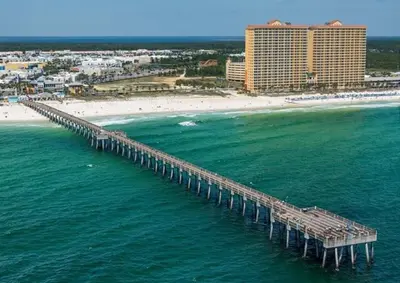 an aerial view of a pier over the ocean with a beach at Calypso 908W Stunning condo, beach front, and immaculate in Panama City Beach