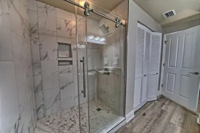 a bathroom with a shower with a glass door at Aqua 707 in Panama City Beach