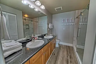 a bathroom with two sinks and a large mirror at Aqua 707 in Panama City Beach
