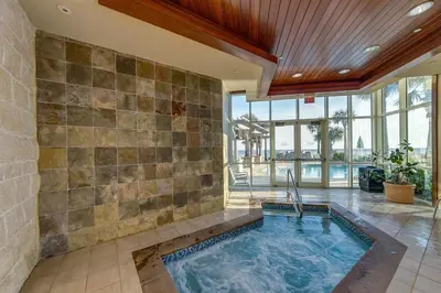 an indoor swimming pool in a room with a stone wall at Aqua 707 in Panama City Beach