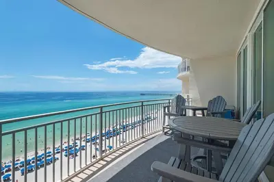a balcony with chairs and a table and the ocean at Aqua 901 in Panama City Beach