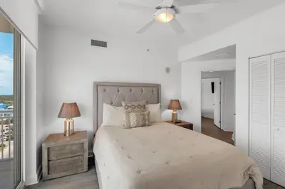 a bedroom with a large bed with two lamps and a window at Aqua 901 in Panama City Beach