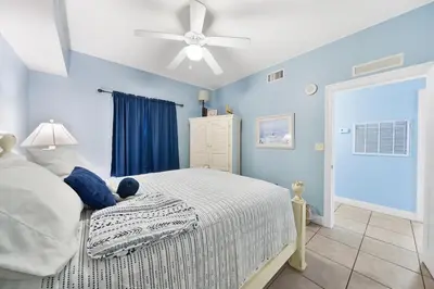 a bedroom with a bed and a ceiling fan at Calypso 108W Like having your private beach house! Beachfront! in Panama City Beach