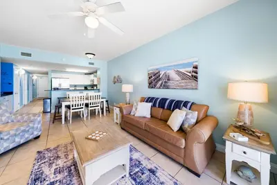 a living room with a couch and a table at Calypso 108W Like having your private beach house! Beachfront! in Panama City Beach
