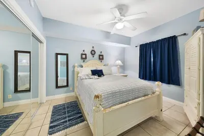 a bedroom with a bed and a ceiling fan at Calypso 108W Like having your private beach house! Beachfront! in Panama City Beach