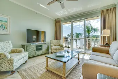 a living room with a couch and a tv at Calypso 202E Paradise at Calypso 4 chairs daily Gulf Front in Panama City Beach