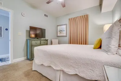a bedroom with a large bed and a television at Calypso 202E Paradise at Calypso 4 chairs daily Gulf Front in Panama City Beach