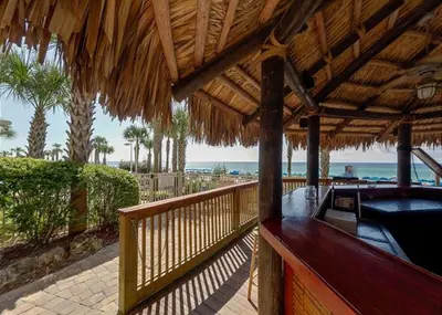 a resort deck with a bar with the beach in the background at Calypso 202E Paradise at Calypso 4 chairs daily Gulf Front in Panama City Beach