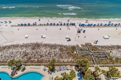 an overhead view of a beach with umbrellas and the ocean at 1403 Aqua in Panama City Beach
