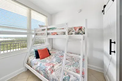 a white bunk bed in a room with a window at 1403 Aqua in Panama City Beach