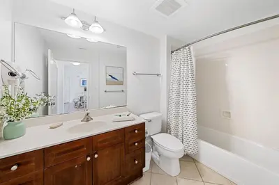 a bathroom with a sink and a toilet and a mirror at 1403 Aqua in Panama City Beach
