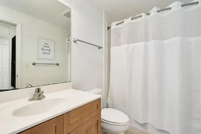 a white bathroom with a sink and a toilet at Aqua 2004 in Panama City Beach
