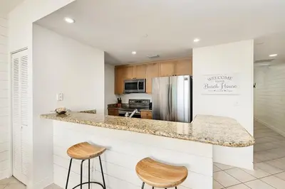 a kitchen with a counter and two stools at Aqua 2004 in Panama City Beach