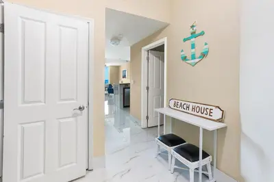 a hallway with a door and a table and a chair at Aqua 2008 in Panama City Beach