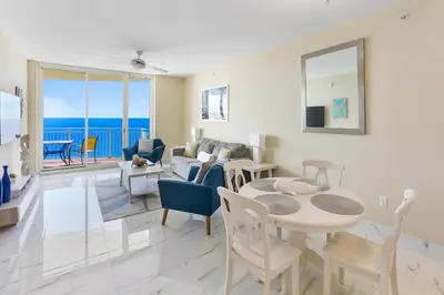 a living room with a table and chairs and the ocean at Aqua 2008 in Panama City Beach