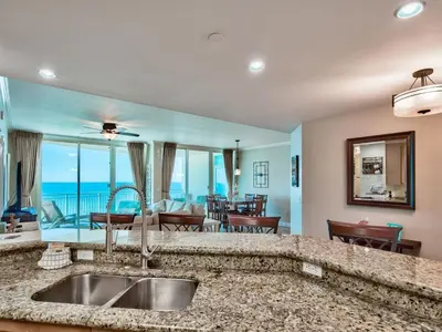 a kitchen with a sink and a living room at Aqua 2102 in Panama City Beach