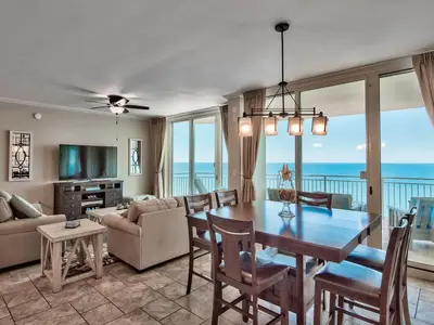 a living room with a dining table and a view of the ocean at Aqua 2102 in Panama City Beach