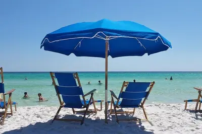 a group of chairs and an umbrella on a beach at Aqua 2102 in Panama City Beach
