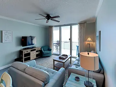 a living room with a couch and a tv at Palazzo 1406 by Emerald Coast Retreats in Panama City Beach