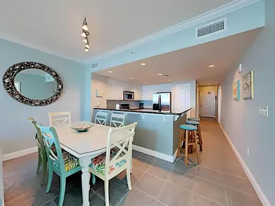 a kitchen and dining room with a table and chairs at Palazzo 1406 by Emerald Coast Retreats in Panama City Beach