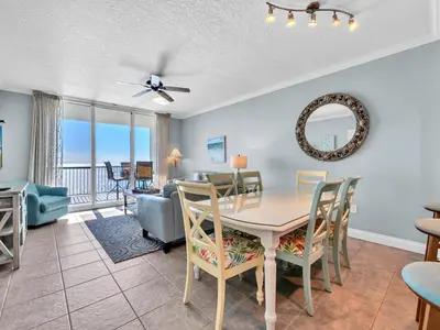 a dining room and living room with a table and chairs at Palazzo 1406 by Emerald Coast Retreats in Panama City Beach