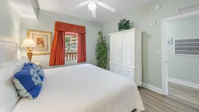a bedroom with a white bed and a window at Calypso 206W Low Floor West Tower No elevators needed in Panama City Beach
